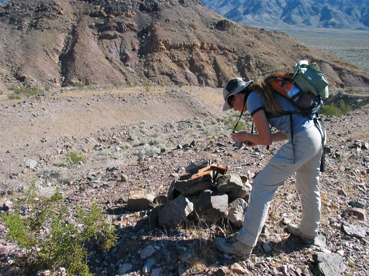 On the hike back down, Niki stops to check out a claim marker.