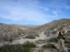 The canyon exits into the northwest corner of Harper Flat.  Jamie scouts the area with her monocular. (86kb)