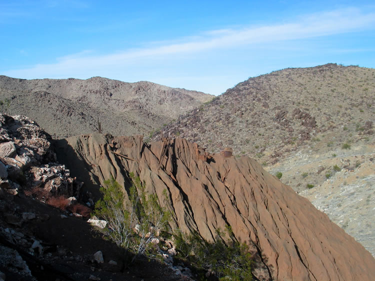 We're not sure what the timbers are for that stick out of the top of the tailings.  Were they supports for rails to facilitate the use of an ore cart to dump the material?