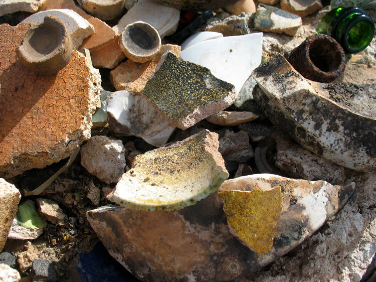 In the assaying process, after the ore sample and fluxes are heated in the crucible, the resulting precious metals and lead sink through the slag to the bottom of the crucible.  This would then be poured in a mold to cool.  After cooling, the assayer would use a hammer to break off the glassy looking slag.