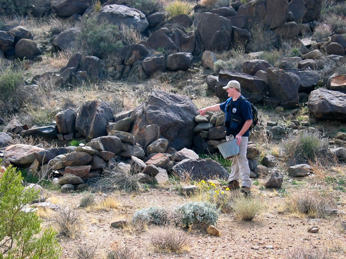 Off to the side, Dan spots some fallen dry stacked stone foundations and finds an old bucket.