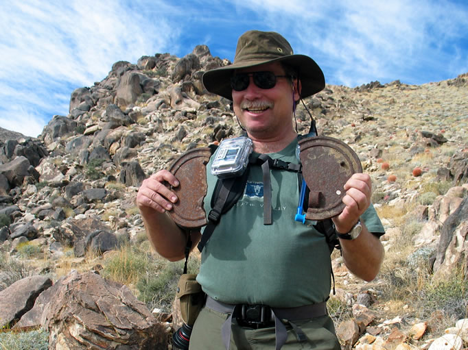 Lewis holds up either breast protectors or cast iron cook stove covers.