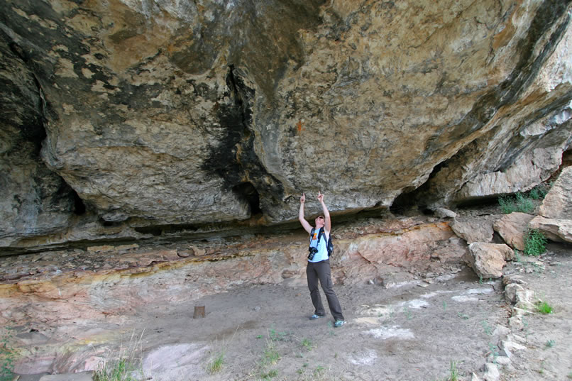 Although all cultural remains were removed during the excavation, the original pictographs and petroglyphs remain.  Here Niki is pointing up at our favorite, the orange lizard pictograph.