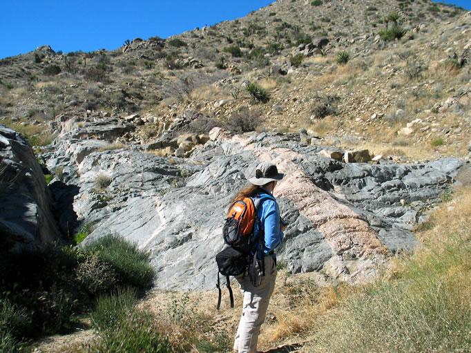 Niki looks at the wide pinkish feldspar vein as the little stream tinkles down the cleft to the left.