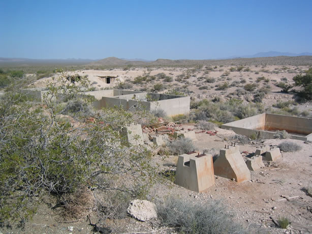 Miners' dugouts behind mill ruins.