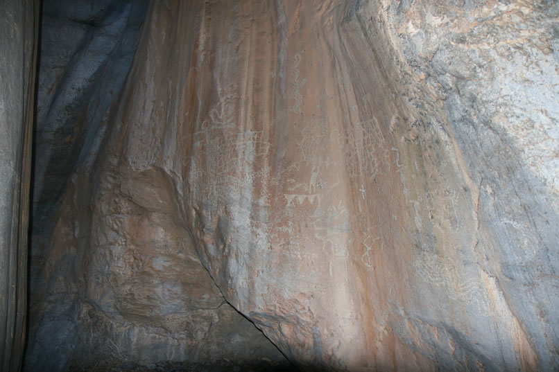 Near the back of the alcove, though, we find a nice panel of petroglyphs pecked into the reddish-tan rock face. If you roll your mouse over the image you can get an enhanced view.