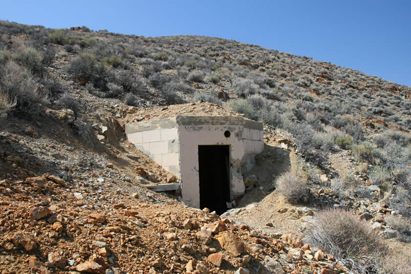 A trail behind the headframe leads a short way up the canyon to what appears to have been a powder storage structure.