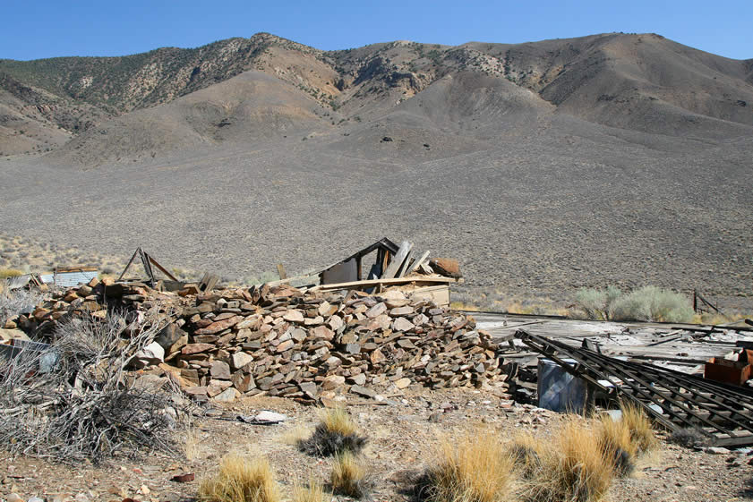 The stacked stone wall on the side of the old root cellar.