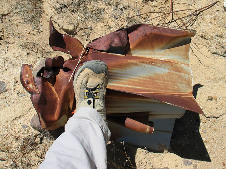 Niki's foot gives some scale to the rocket remains.  These tail sections are fairly intact, while the upper sections are all badly accordioned. 