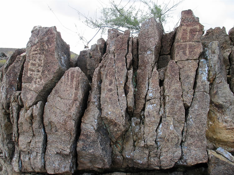 The petroglyph in the upper right looks very much like the stylized image of front facing bighorn horns found in the Coso region.