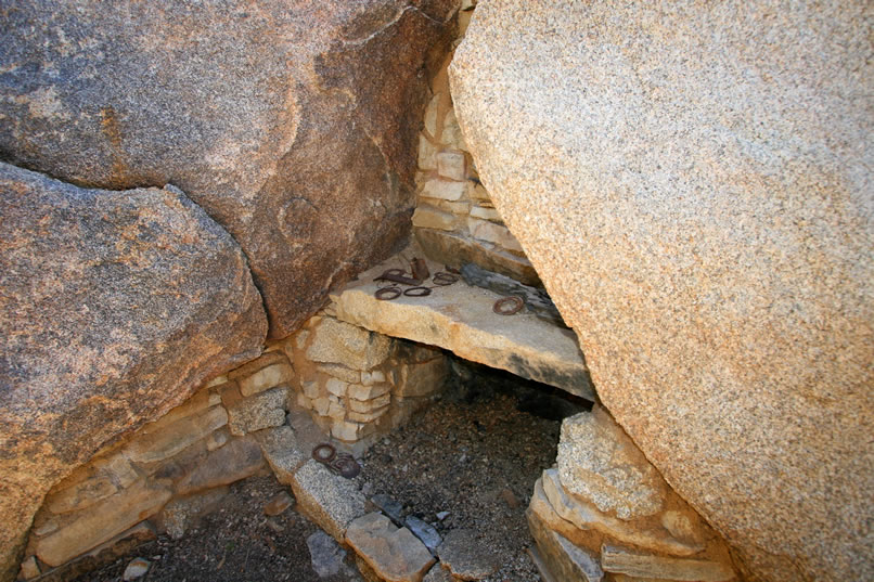 A view of the fireplace from a different angle shows some of the construction details.  Also, scattered on the fireplace mantle you can see some hole and cap can tops that are missing the soldered cap portion.
