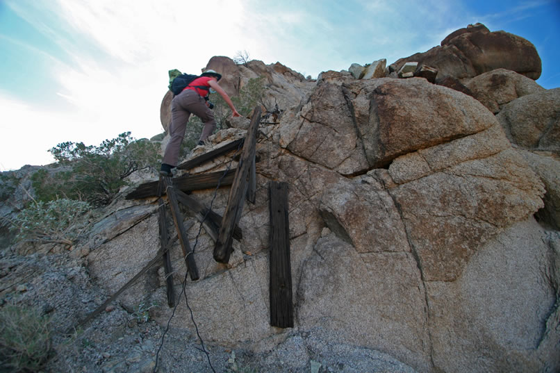 Niki scrambles up above the wooden ruins of the tower to check it out.