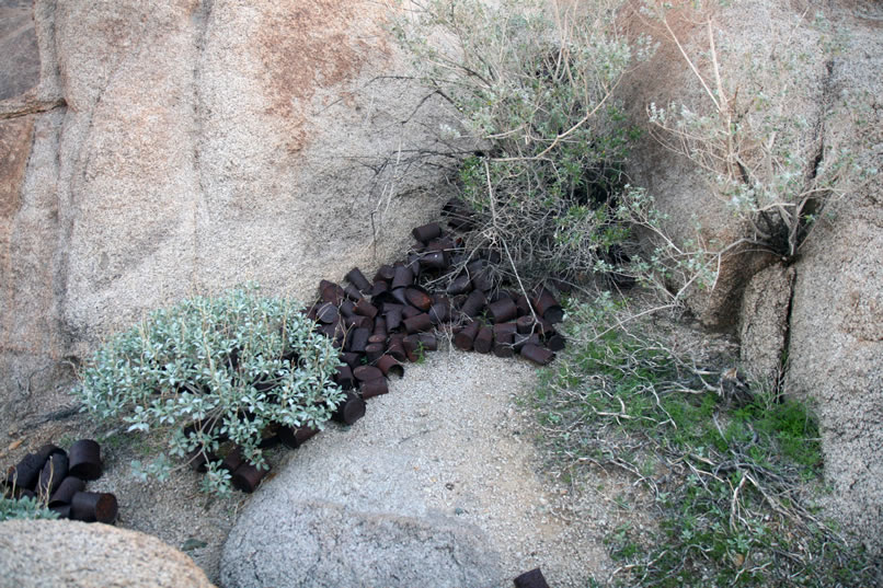 A large can scatter in one of the niches in the boulder pile.