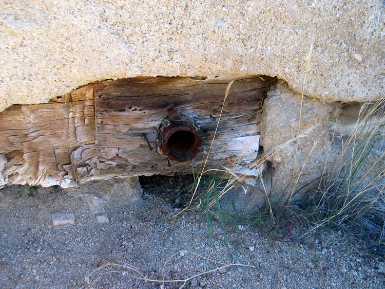 The wheel has an inner wood frame through which a metal central pipe has been inserted to serve as an axle.  The whole assembly was then covered with cement.