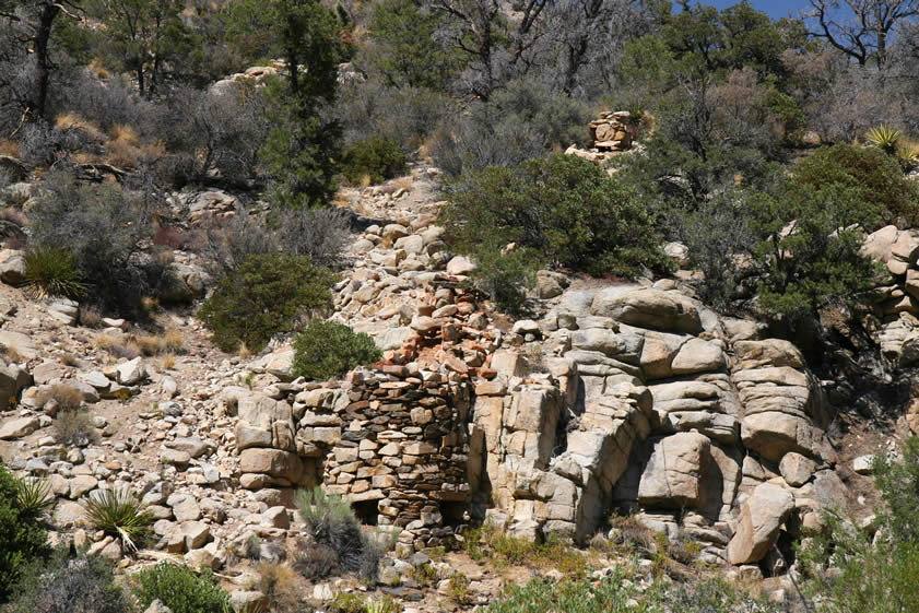 In this closer view you can not only see the smelter structure but also the extended flue that runs up the hillside to a square chimney affair further up the slope.