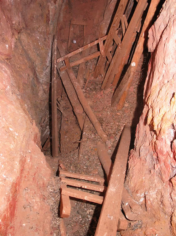 We finally come to the base of the main shaft.  The cave-in and debris that we could see from the surface looks just as bad down here.  It appears that the shaft once continued to a lower level.  Possibly the quartz vein is still exposed in these lower levels but there's no way that we're going to get down there!