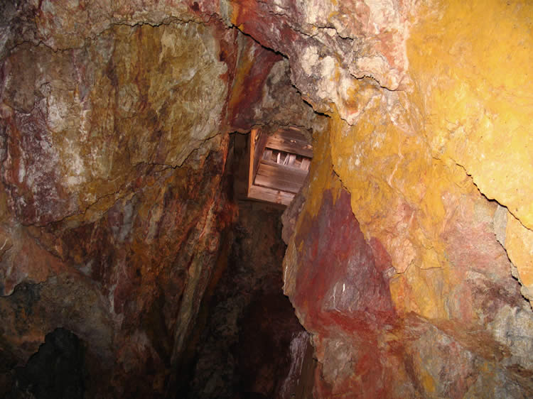 Looking up from the cave-in area gives us a view of the bottom of the headframe shaft.  Some daylight filters down from that opening.