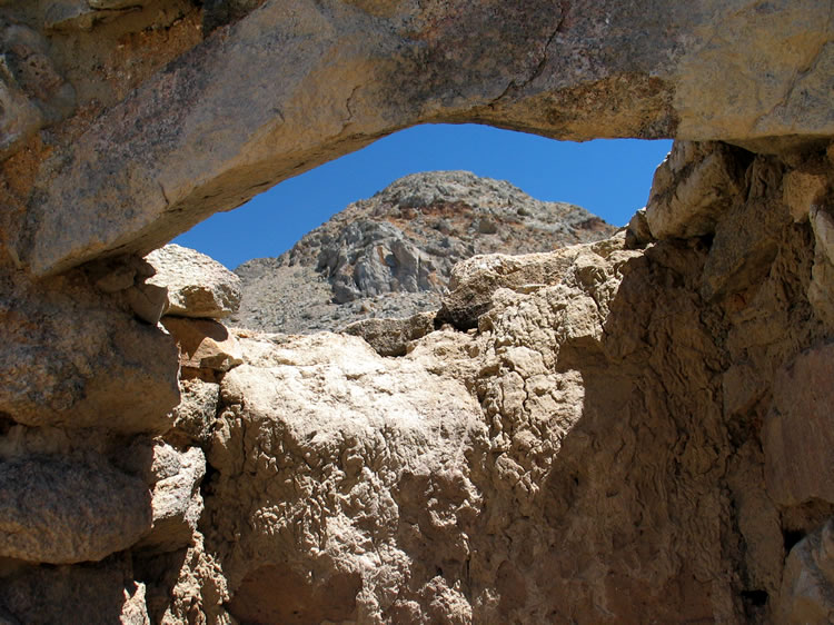 The collapsed chimney provides a view of a nearby peak.
