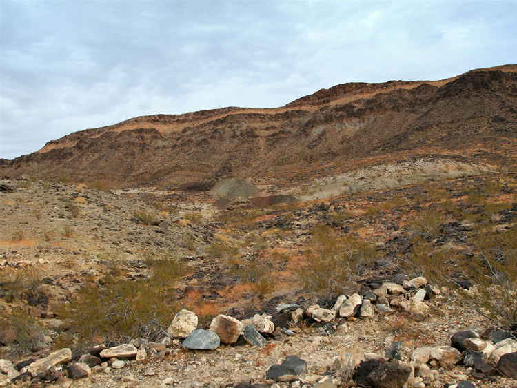 The large tailings piles mark the site of this old iron mine.  The Paul shipped ore in 1918 during World War I and has lain dormant ever since.  The access road which used to wind upward amidst fields of lava boulders has long since deteriorated to nothing more than a rocky rut.