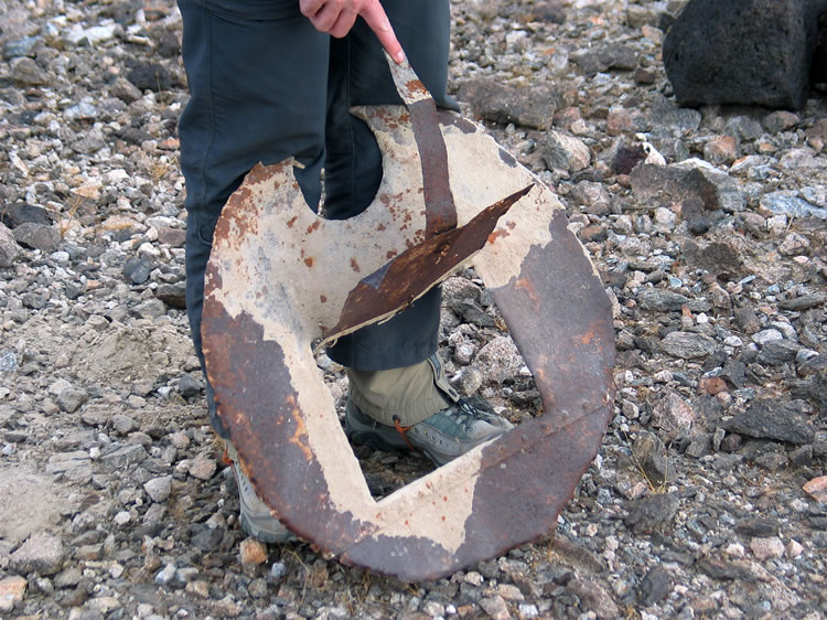 Parts of what appear to be a stove are found nearby along with some scattered cans.