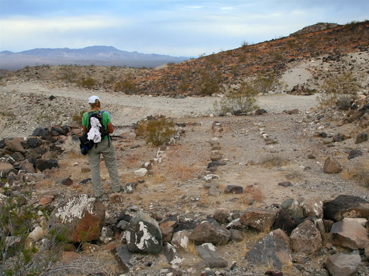 Just below the eroded portion of the road we come upon what appears to have been a cluster of structures.  Here Jamie explores the largest of the building sites.