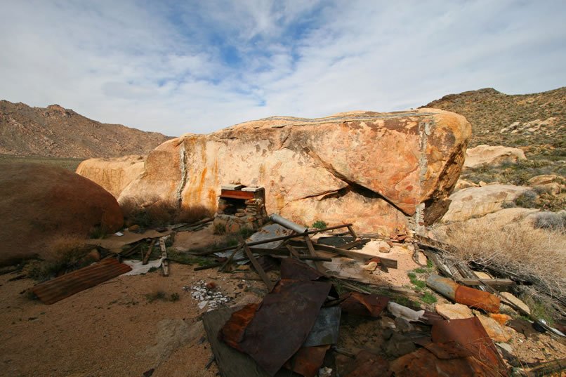 Sadly, the old cabin is no longer standing.  You can see where the walls and roof were cemented to the boulder which formed the rear wall.