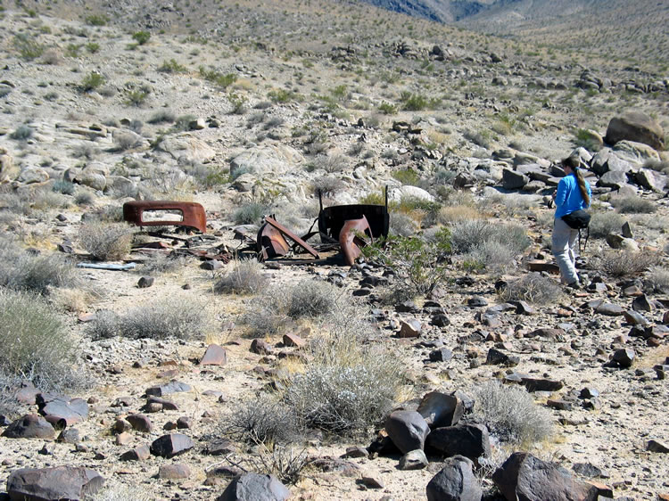 Just beyond the rock ruins is an old car body.