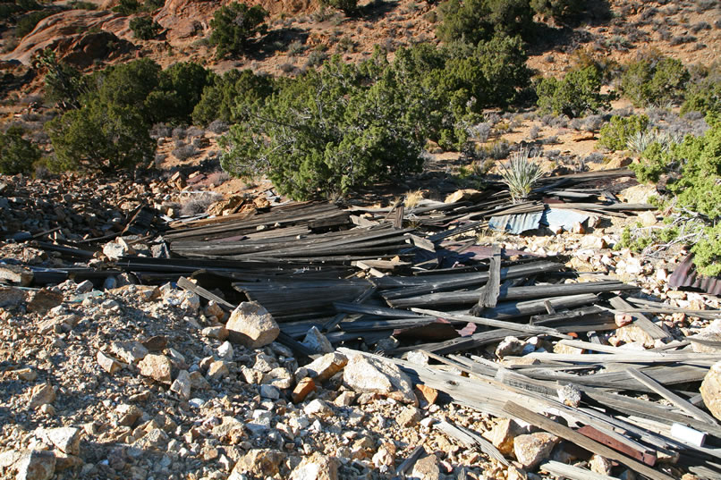 We're surprised that there are no structures here at the mine site but then we happen to look over the side of the ridge and see the remains of what once was a sizeable wood building.