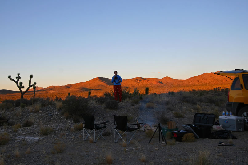 The sunset glow paints the hills in the distance as dinner cooks on the fire.