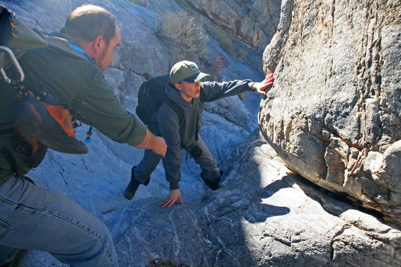 Micah lends Annie a hand up a slippery chute.