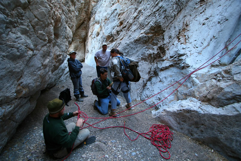 Guy gets the climbing harness set up for Alysia.